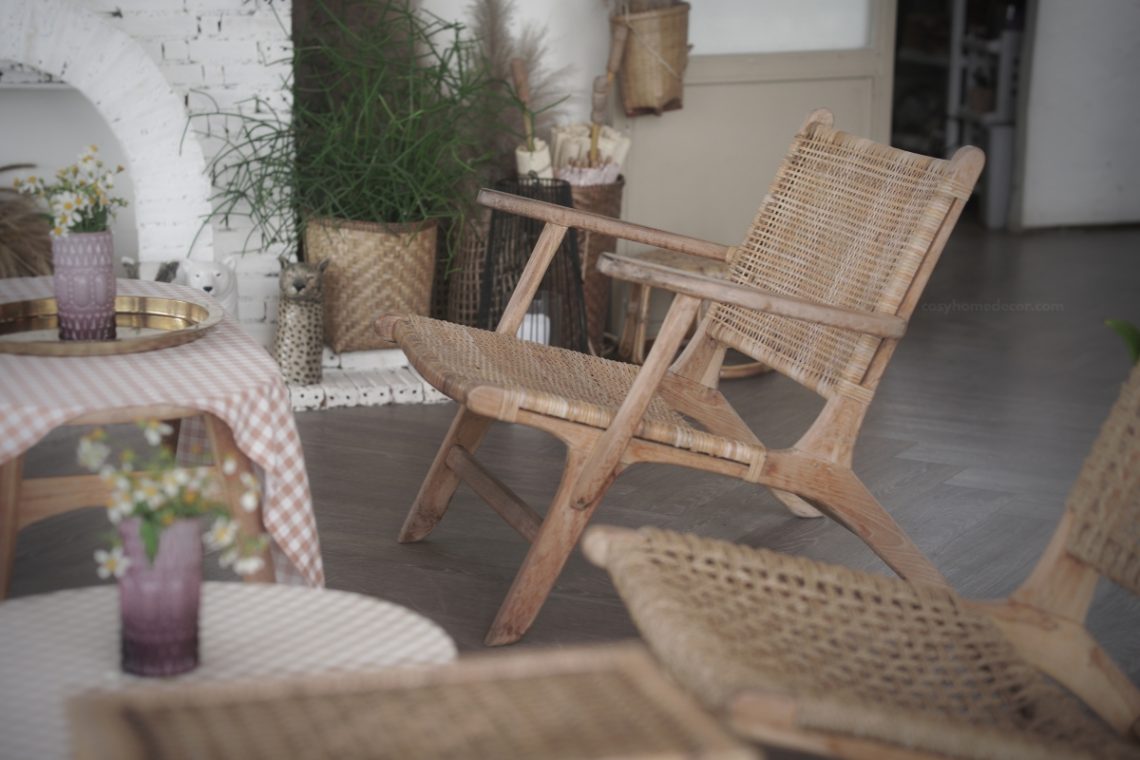 Deep round papasan rattan chair with a thick cream cushion in a warm boho reading nook